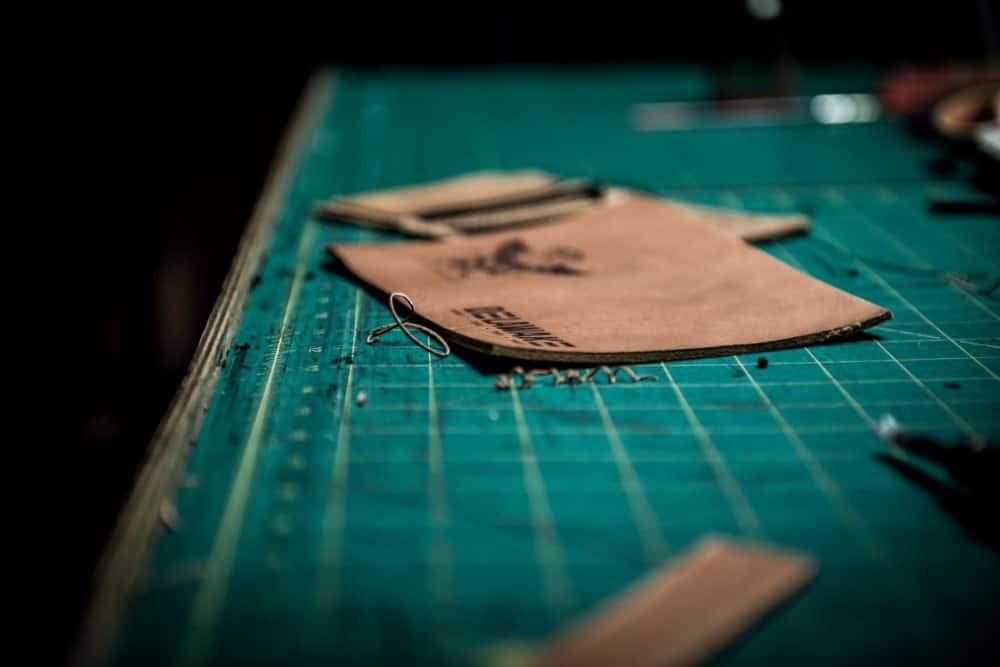 article: best handmade leather wallets image: leather sections being worked on to make a wallet