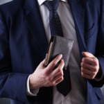 Article: Are Expensive Wallets Worth It? Image: wallet in suited mans hands
