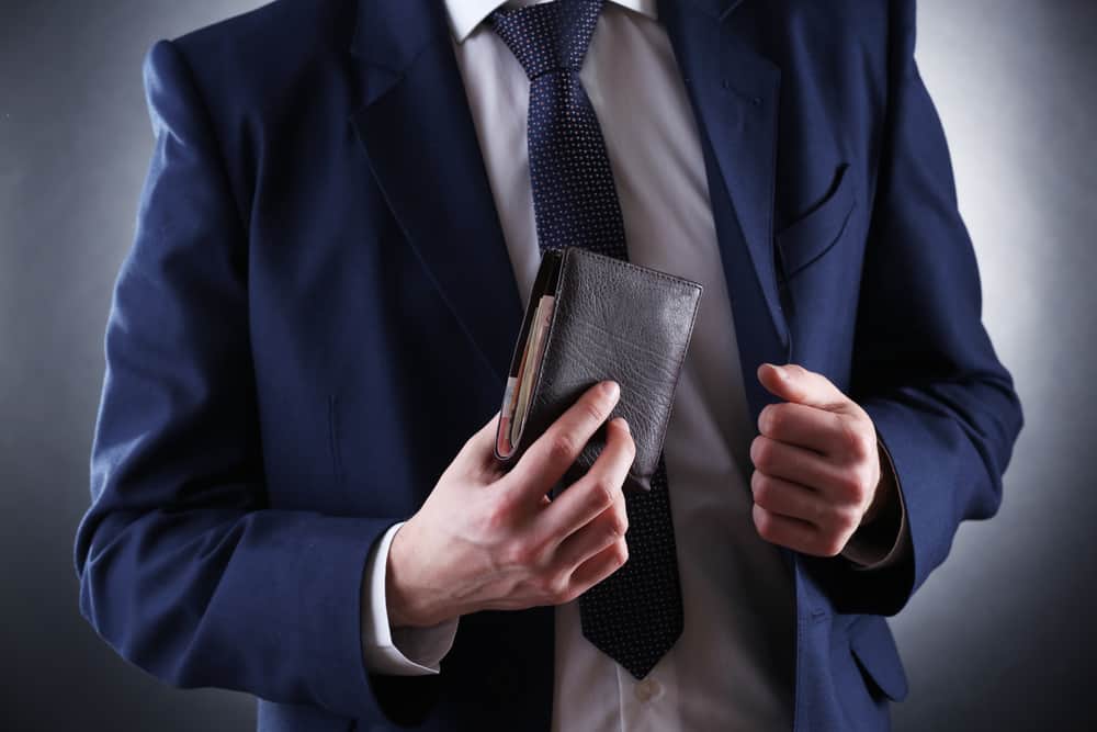 Article: Are Expensive Wallets Worth It? Image: wallet in suited mans hands