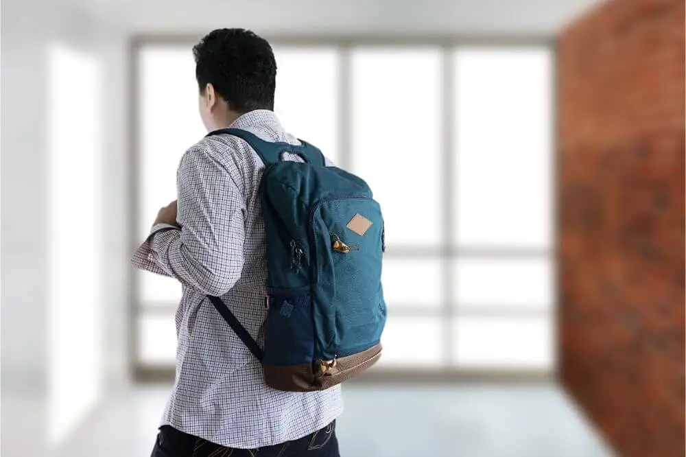 Different Types of Backpacks: young man with study or work materials in backpack