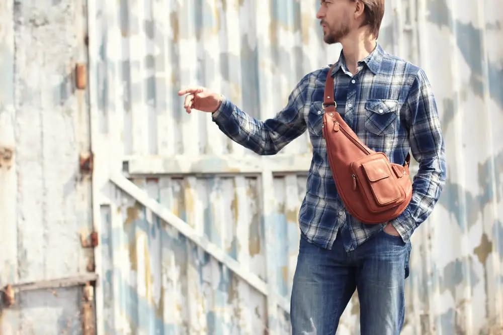 Hipster wearing single strap crossbody style backpack in front