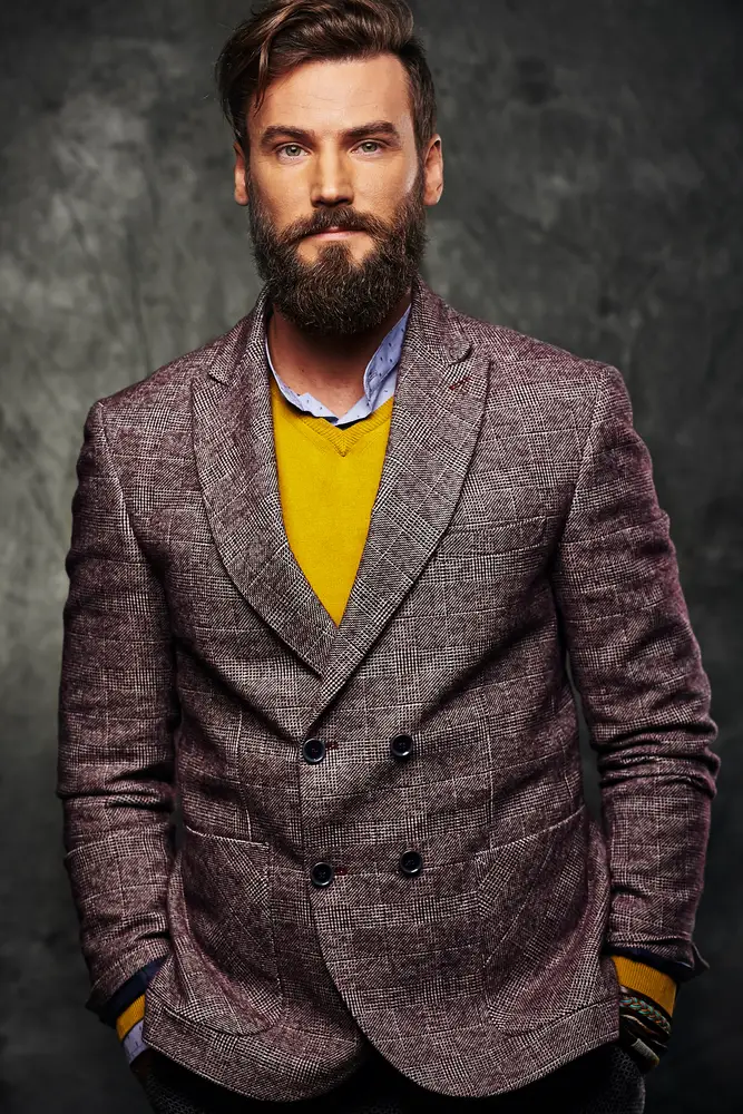 Article: How to match clothes for guys. Image shows man with pop of color from yellow sweater