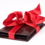 Article: Giving a Wallet as a gift. Image shows a wallet wrapped in a red bow