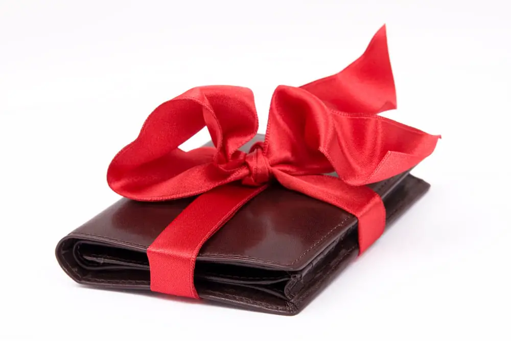 Article: Giving a Wallet as a gift. Image shows a wallet wrapped in a red bow